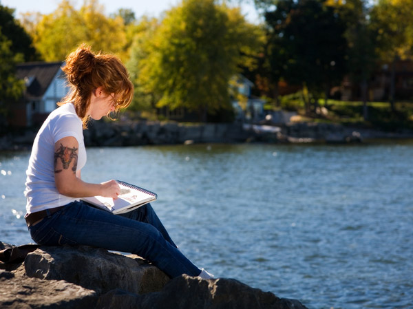 artist drawing at the river to sketch a scene